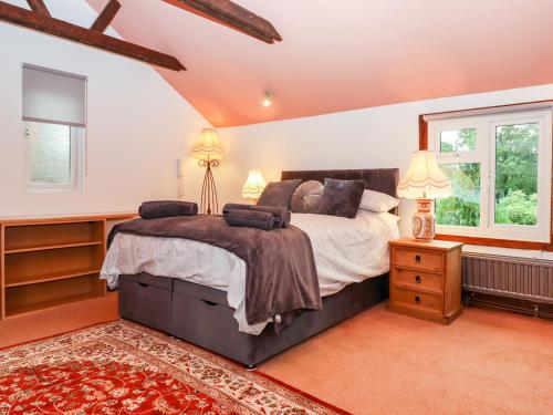 a bedroom with a large bed and two windows at Hazeldene Stables in Exeter