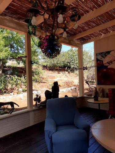 - un salon avec une chaise bleue devant une fenêtre dans l'établissement Villa Norte, à Ma‘yan Barukh