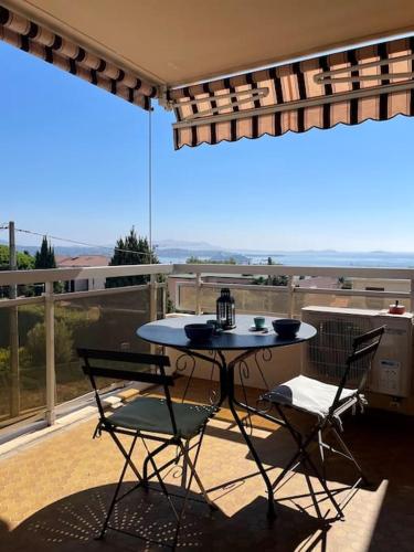 un patio avec une table et des chaises sur un balcon dans l'établissement Tout proche gare et port, vue mer, clim et parking, à Bandol