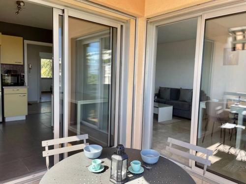 - une table avec des bols dans le salon dans l'établissement Tout proche gare et port, vue mer, clim et parking, à Bandol