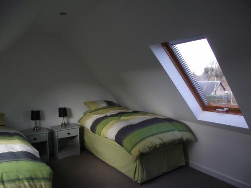 a bedroom with two beds and a window at 6B Church St. Dingwall Apartment in Dingwall
