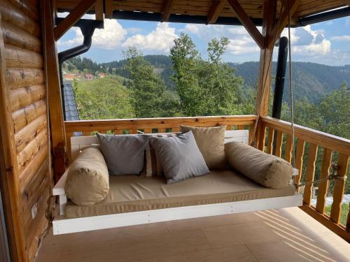 a couch sitting on the porch of a cabin at Zlatar Resort & SPA in Nova Varoš