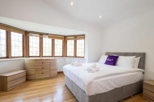 een slaapkamer met een groot bed en een aantal ramen bij Pillo Rooms - Abbey Grove in Manchester