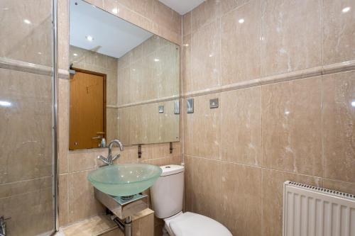 bagno con servizi igienici e lavandino in vetro di Pillo Rooms - Abbey Grove a Manchester