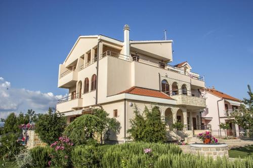 un gran edificio blanco con flores delante en Pansion Skelin en Drinovci