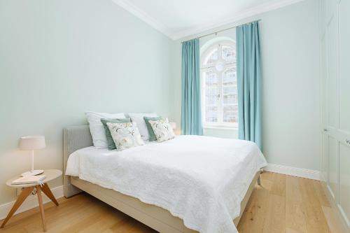 a white bedroom with a bed and a window at Villa Schwan Wohnung 03 in Heiligendamm