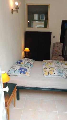 a small bedroom with a bed and a chair at L'ombrelle in Carcassonne