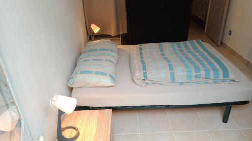 Cama pequeña en habitación pequeña con 2 almohadas en L'ombrelle, en Carcassonne