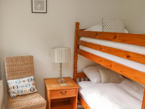 a bedroom with two bunk beds and a chair at 3 Bonaventure Close in Salcombe