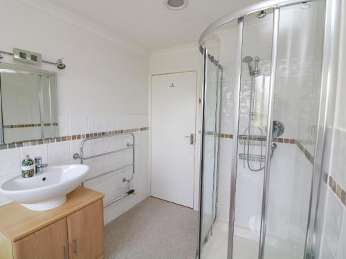 a bathroom with a sink and a glass shower at 3 Bonaventure Close in Salcombe