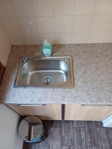 a kitchen sink with a bottle of soap on it at Guest House Lili in Petrich
