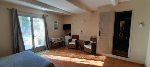 a room with a bed and chairs and a window at Le Mas des Vergers in Salon-de-Provence