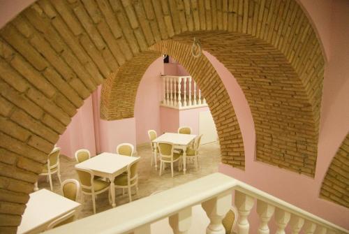 a room with tables and chairs and a brick wall at Palazzo Reginella in Bovalino Marina
