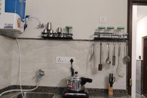a kitchen counter with a mixer and utensils on a shelf at Compact yet beautiful 1bhk 305 in Bangalore