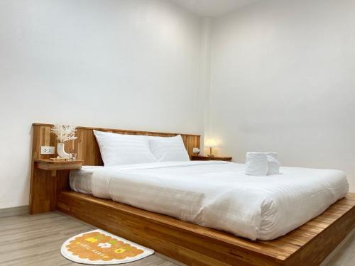 1 dormitorio con 1 cama grande con sábanas blancas en Jinbo Betong Home Cafe’ en Betong