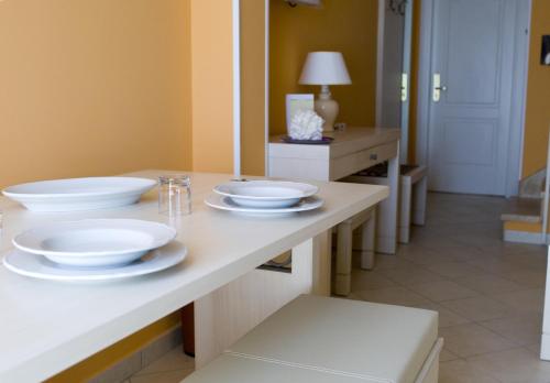 a table with three white plates on it at Palazzo Reginella in Bovalino Marina