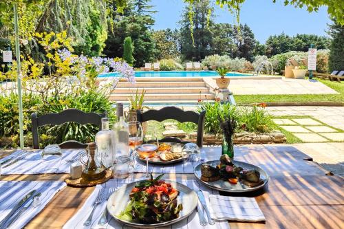une table en bois avec des assiettes de nourriture dessus dans l'établissement Hotel Moulin d'Aure, à Saint-Rémy-de-Provence