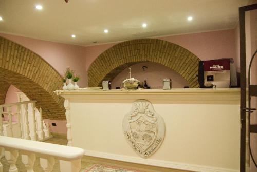 a kitchen with a counter with a shield on the wall at Palazzo Reginella in Bovalino Marina