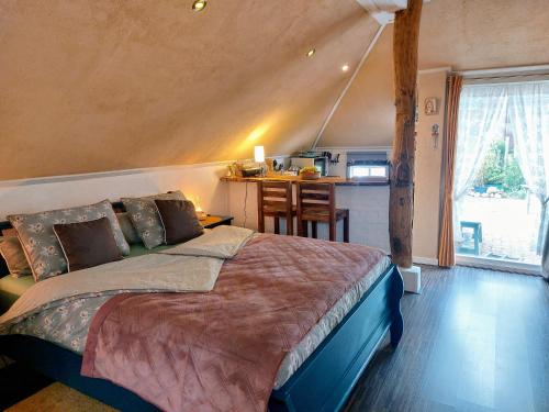 um quarto com uma cama grande e uma cozinha em Logeerboerderijtje De Rietkap Gieten em Gieten