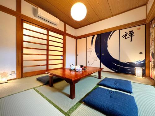 a room with a table and two blue mats at guesthouse森之宮【青丸】 in Osaka