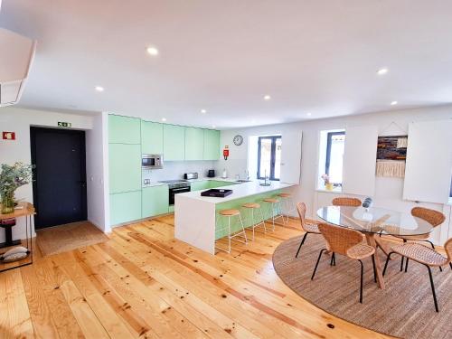 a kitchen and dining room with a table and chairs at Tílias House in Covilhã