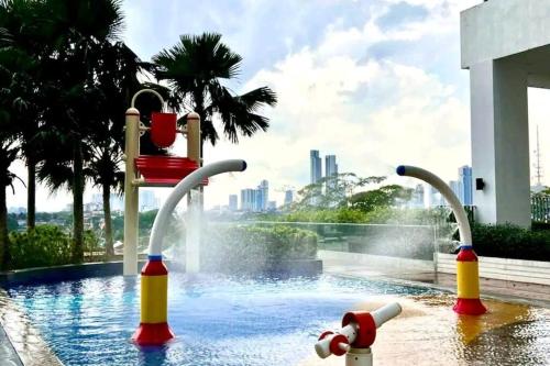 einen Pool mit einem Wasserpark mit einem Brunnen in der Unterkunft Mid Valley Southkey with Bathtub and Straits View for family toodlers 8 to 14pax in Johor Bahru