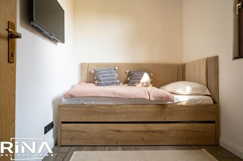 um quarto com uma cama e uma televisão na parede em Kuća za odmor Rina em Pakrac