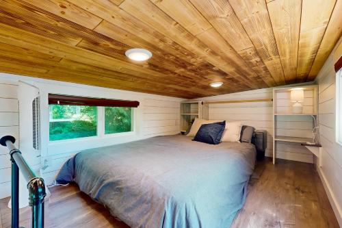 uma cama num pequeno quarto com tecto em madeira em Tiny Tiger em Issaquah