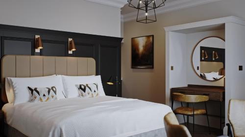 a bedroom with a white bed and a mirror at King Street Aparthotel in Stirling