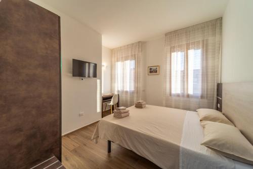 a bedroom with a bed and a tv on a wall at Mentana Rooms in Parma