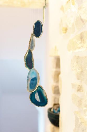 a group of blue glass beads hanging from a wall at Kalma villa in Santa Maria