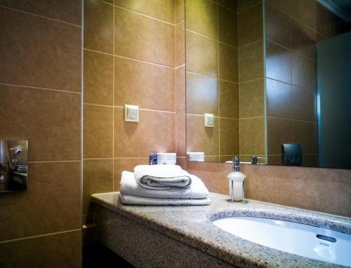 a bathroom with a sink and a mirror at Armeno beach hotel in Nydri