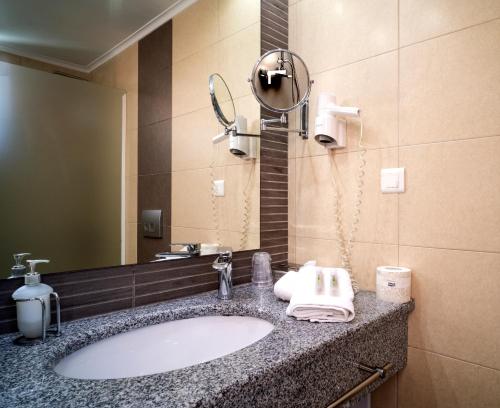 a bathroom with a sink and a mirror at Armeno beach hotel in Nydri