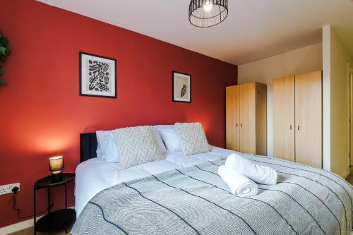 a bedroom with red walls and a large bed at Central Mcr apt near AO arena, parking available nearby in Manchester