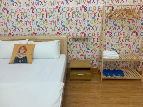 a bedroom with a bed and a wall with a mural at Villa sân vườn Misa in Phan Thiet