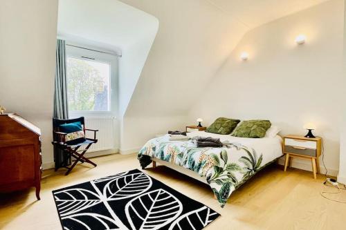 Schlafzimmer mit einem Bett, einem Schreibtisch und einem Fenster in der Unterkunft Ti Bras - la grande maison in Crozon