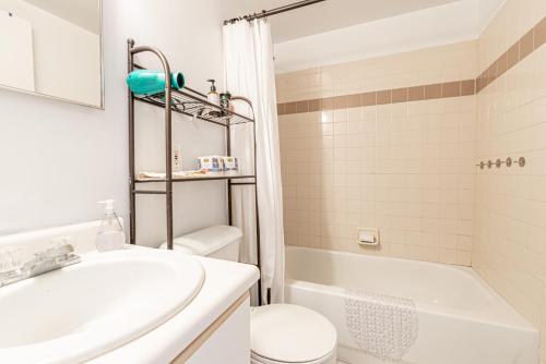 a bathroom with a sink and a toilet and a tub at Stunning 2 BR in Manhattan in New York