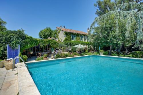 a swimming pool in front of a house at Hotel Moulin d'Aure in Saint-Rémy-de-Provence