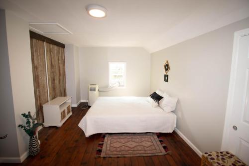 ein weißes Schlafzimmer mit einem weißen Bett und einem Fenster in der Unterkunft Large Beautiful Apartment (Unit 40) in Hershey
