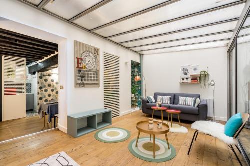 un salon avec un canapé et une table dans l'établissement Appartement chic avec patio - 2BR 6P - Le Marais, à Paris