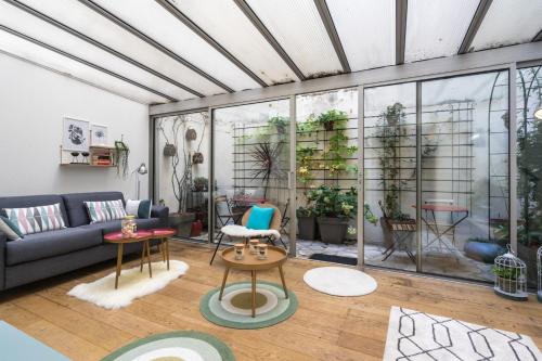 un salon avec un canapé et une table dans l'établissement Appartement chic avec patio - 2BR 6P - Le Marais, à Paris