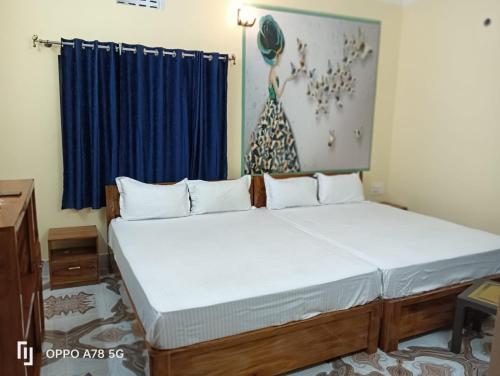 a bedroom with a large bed with a blue curtain at TITILI PLAZA in Puri