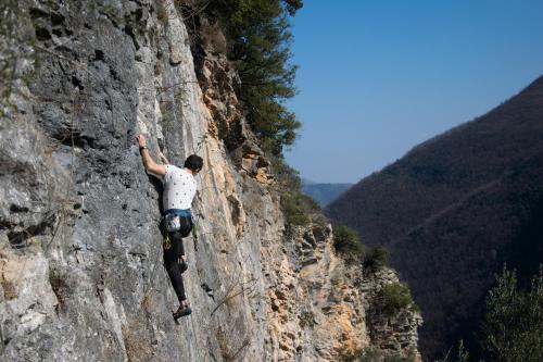 a man climbing a rock wall on a mountain at Villa Essenza - Rooms and Breakfast in Albenga