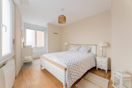una camera da letto bianca con un letto e una finestra di La Perle de Lens - Belle maison avec grande terrasse a Lens