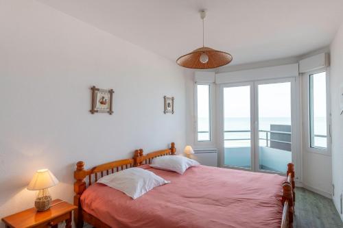 een slaapkamer met een bed met een roze sprei bij Le Trimaran 40 in Mers-les-Bains