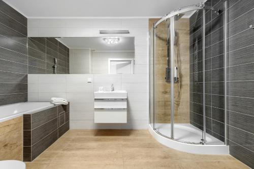 a bathroom with a shower and a sink at Apartament Doris 3- Studio z wanną in Pobierowo