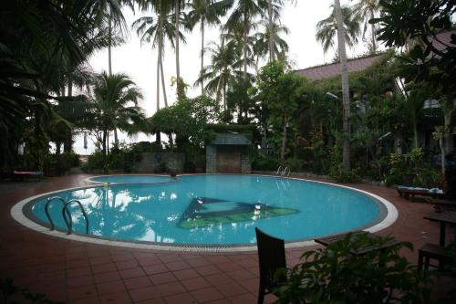 una gran piscina en un complejo con palmeras en Mui Ne Resort, en Mui Ne