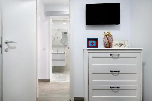 a bathroom with a dresser with a television on a wall at Casa Marion in El Golfo