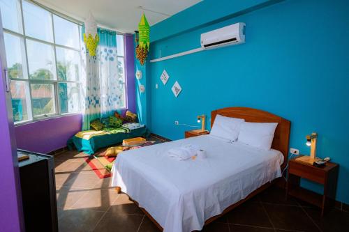 Dormitorio azul con cama y pared azul en HOTEL RAYMONDI, en Pucallpa