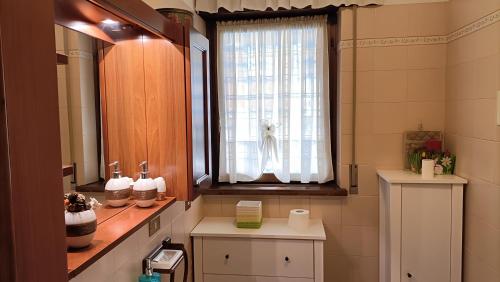 baño con ventana, lavabo y ventana en Monolocale Monti Pallidi, en Domegge di Cadore